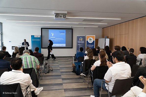 Veranstaltung politische Teilhabe 06.06.2024 - Publikum, fotografiert von hinten, im Hintergrund Leinwand und Dozentin