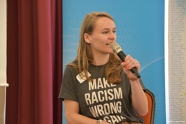 Foto MO VA:Podiumsdiskussion eine Frau sitzend mit Mikrofon in der Hand