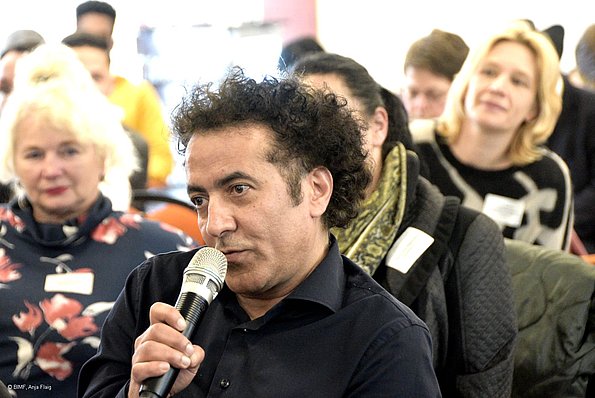 MO VA 20.04.2024 Menschen, sitzend, Publikum, ein Mann spricht in ein Mikrofon