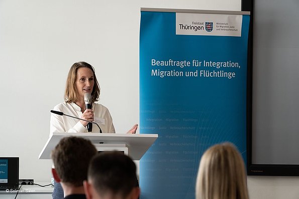 Veranstaltung politische Teilhabe 06.06.2024 - eine Person am Mikrofon, stehend, Beauftragte Mirjam Kruppa