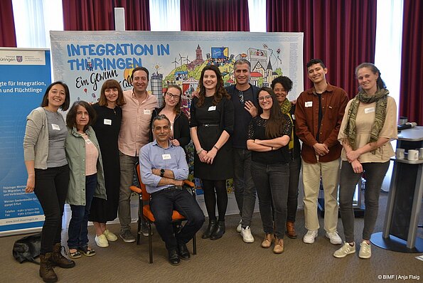 Foto MO VA mehrere Menschen sitzend und stehend vor einem Wimmelbild und Rollup