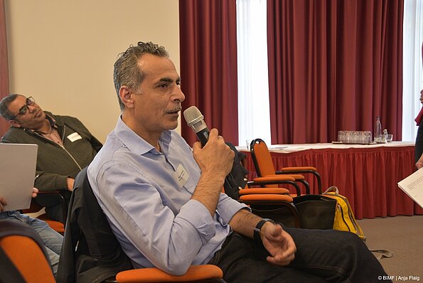 Foto MO VA: ein Mann sitzend auf einem Stuhl mit einem Mikrofon in der Hand