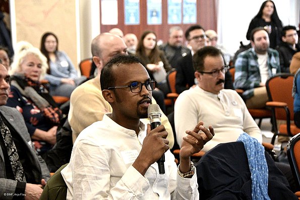 MO VA 20.04.2024 Menschen, Publikum, sitzend, ein Mann mit Brille spricht in ein Mikrofon