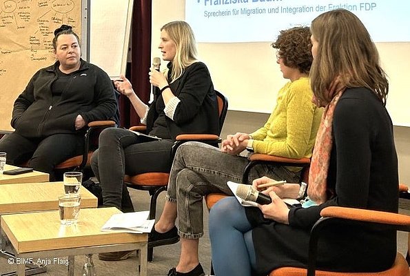 MO VA 20.04.2024 Diskussionsrunde, 4 Frauen sitzend in einer Reihe, eine Frau spricht in ein Mikrofon