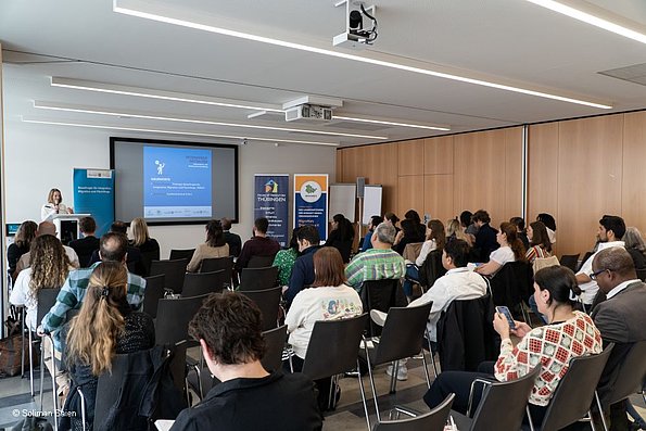 Veranstaltung politische Teilhabe 06.06.2024 - Das Publikum, fotografiert von hinten, im Hintergrund Leinwand, Beauftragte