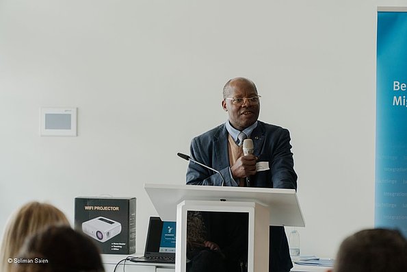 Veranstaltung politische Teilhabe 06.06.2024 - Dozent, eine Person stehend hinter dem Rednerpult am Mikrofon