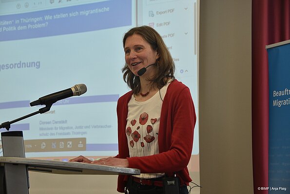 Foto MO VA: Moderation eine Frau stehend am Pult mit Headset