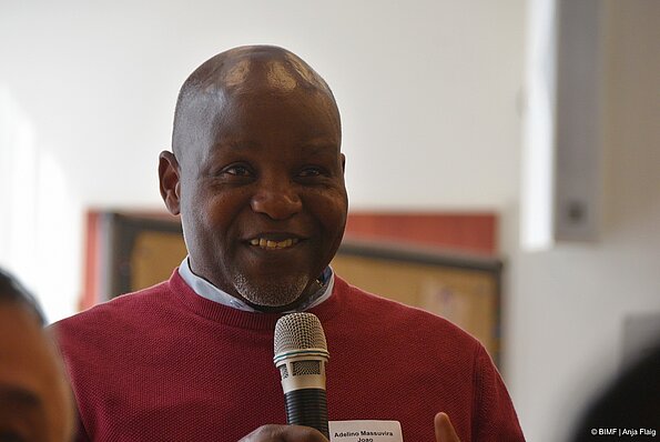 Foto MO VA: ein Mann stehend mit einem Mikrofon in der Hand (lächelnd)