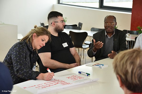 MO VA 17.05.2025 Austauschrunde 3 Personen sitzend, eine Person schreibt etwas auf
