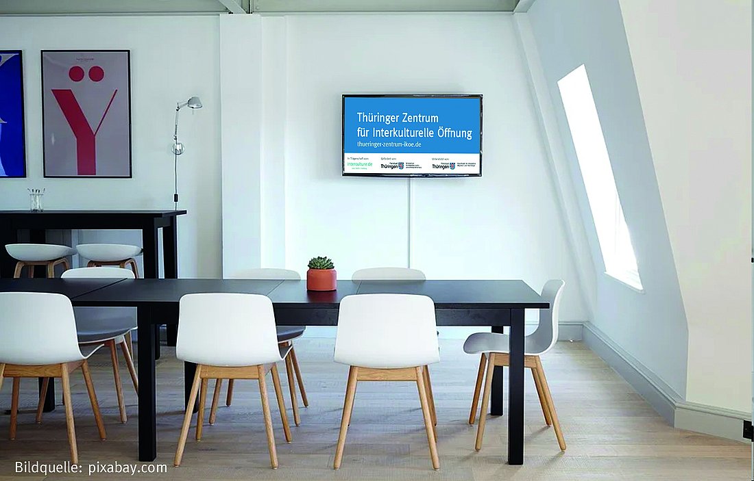 Bild eines Besprechungsraumes mit dem Logo des Zentrums für Interkulturelle Öffnung