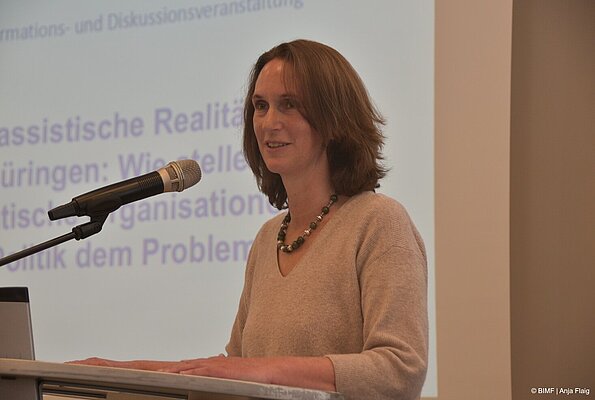 Foto MO VA: Thüringer Beauftragte für Integration, Migration und Flüchtlinge Mirjam Kruppa stehend vor einem Pult, Eröffnungsgrußwort