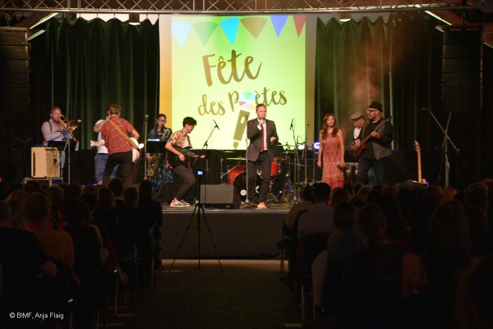 Blick auf die Bühne, Musiker stehend und sitzend, singen